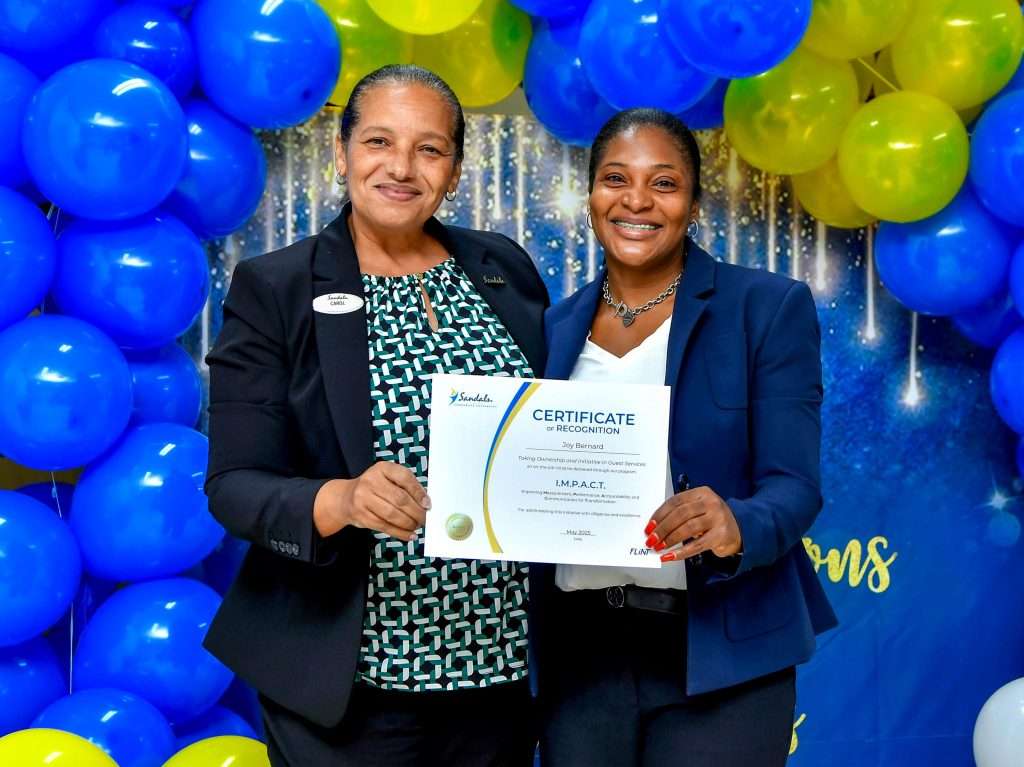 Sandals Ochi Beach Resort General Manager, Carol Bourke (left) presents Learning and Development Manager, Joy Bernard with her certificate of recognition for the role that she played in administering the training initiative.